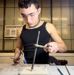Jameson Enriquez works with a blowtorch in studio