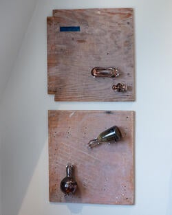 four glass objects mounted onto two wood boards (two glass pieces per board)