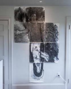 eight pieces of white paper arranged to assemble a black-and-white illustration of a human figure with angel wings