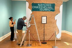 student worker Saachi Mehta and RISD Museum's Brendan Campbell working on display for show honoring the seal