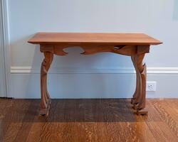 a brown wooden table rests against a white wall