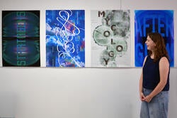 a student discusses posters displayed in a poster design studio