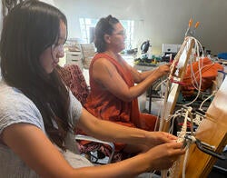 current RISD student Marigold Wong and alum Tanya Aguiniga weaving side by side