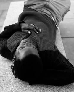 intimate black-and-white photo of a person lying on the carpet