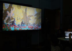 a monitor displaying colorful, digitally-animated figures in a dark room