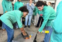 applying a blowtorch to molten glass