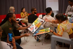 participants pass around prints created in Bidon's workshop