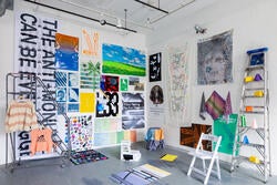 two walls adorned with a diverse range of print objects converge at a corner of the room