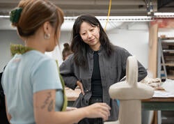 faculty member Chenlu Hou consults with a student