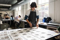 grad student Jeff Smith lays their prints out on a table