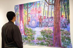 a student examines work by Mala Iqbal