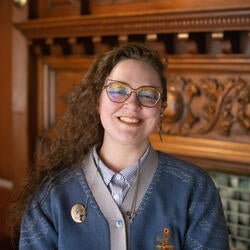 person smiling in front of fireplace