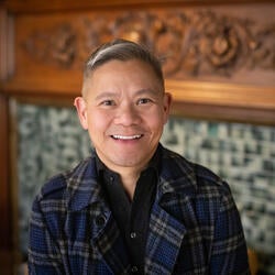 man smiling in front of fireplace