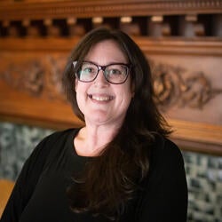 person smiling in front of fireplace