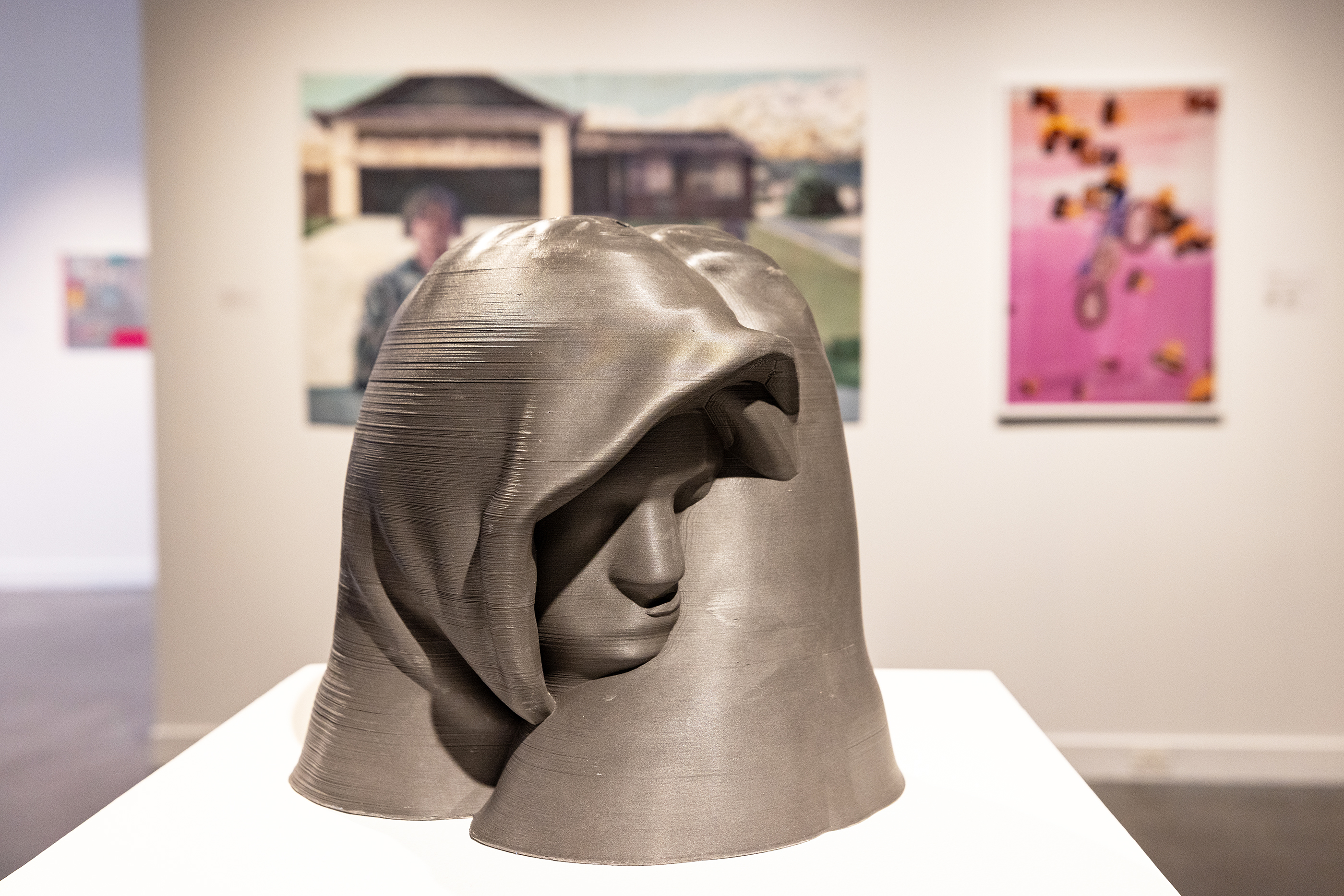 sculpture of two heads in hoodies