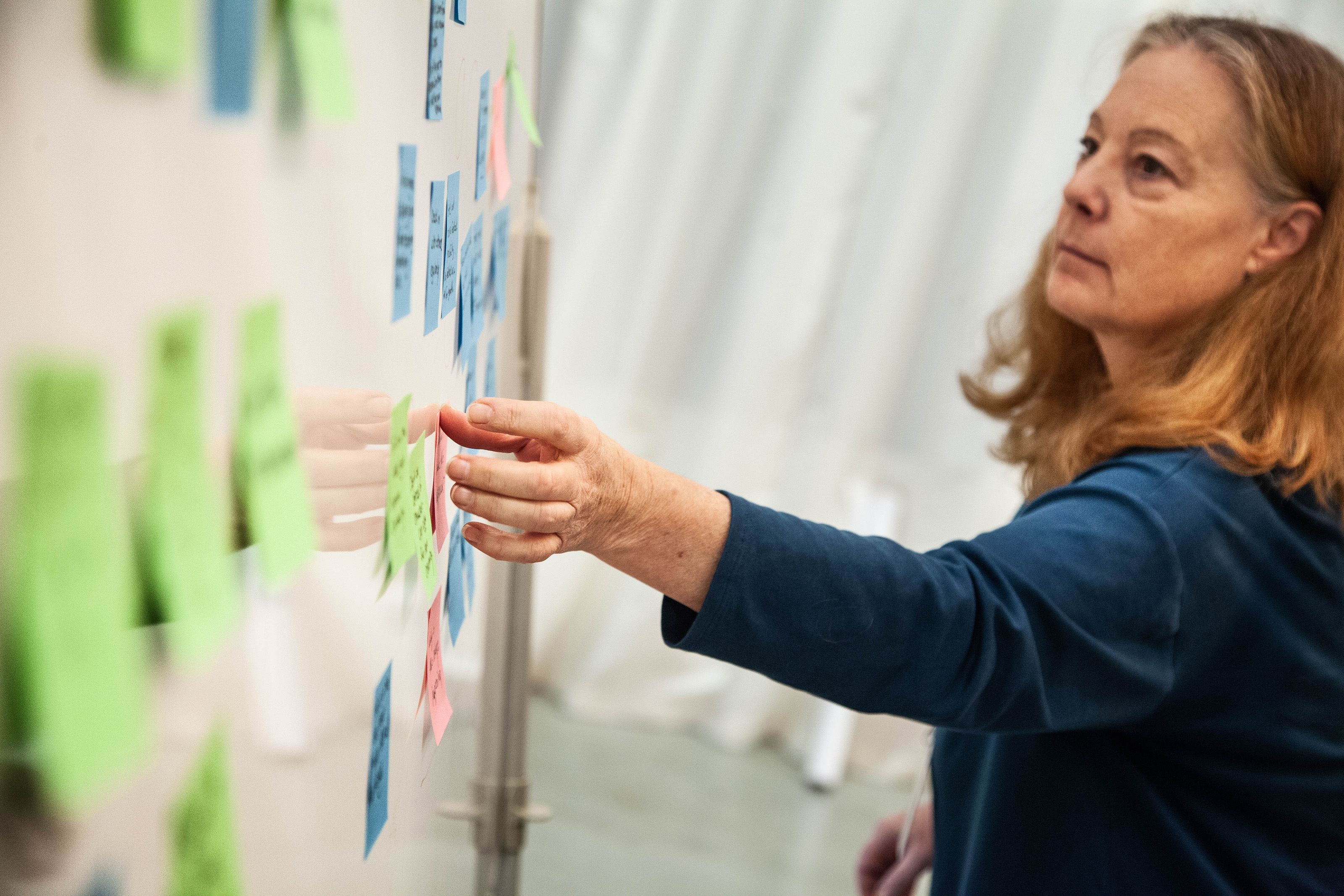 a participant arranges post-its on the wall