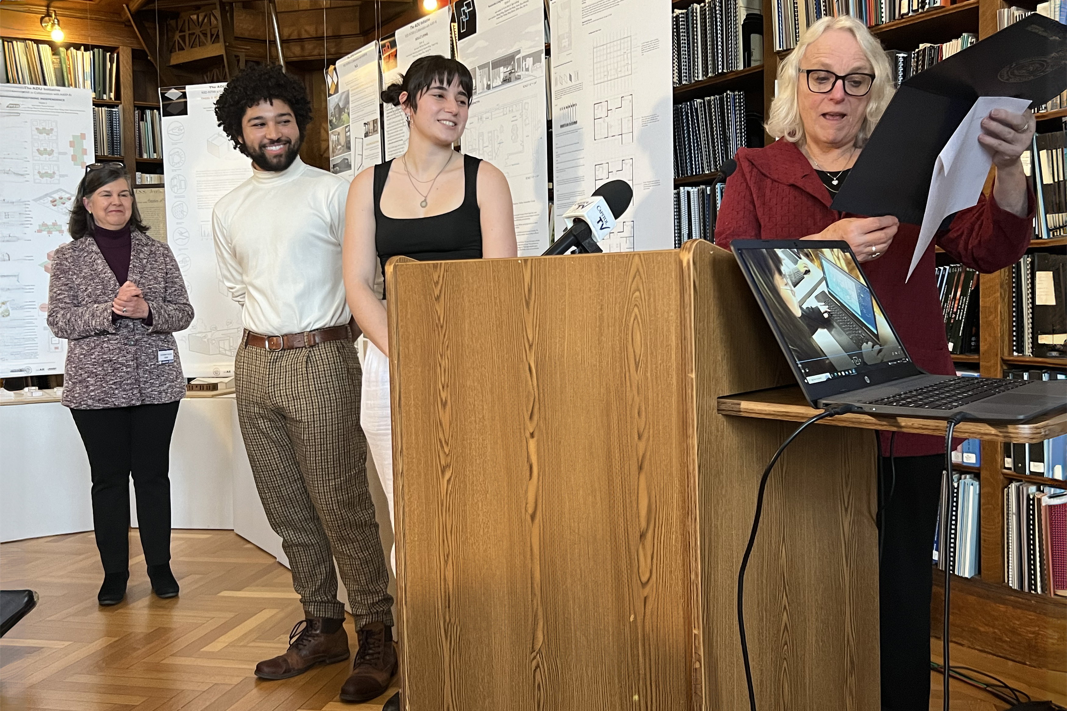 State Representative June Speakman presents a certificate to members of the winning design team.