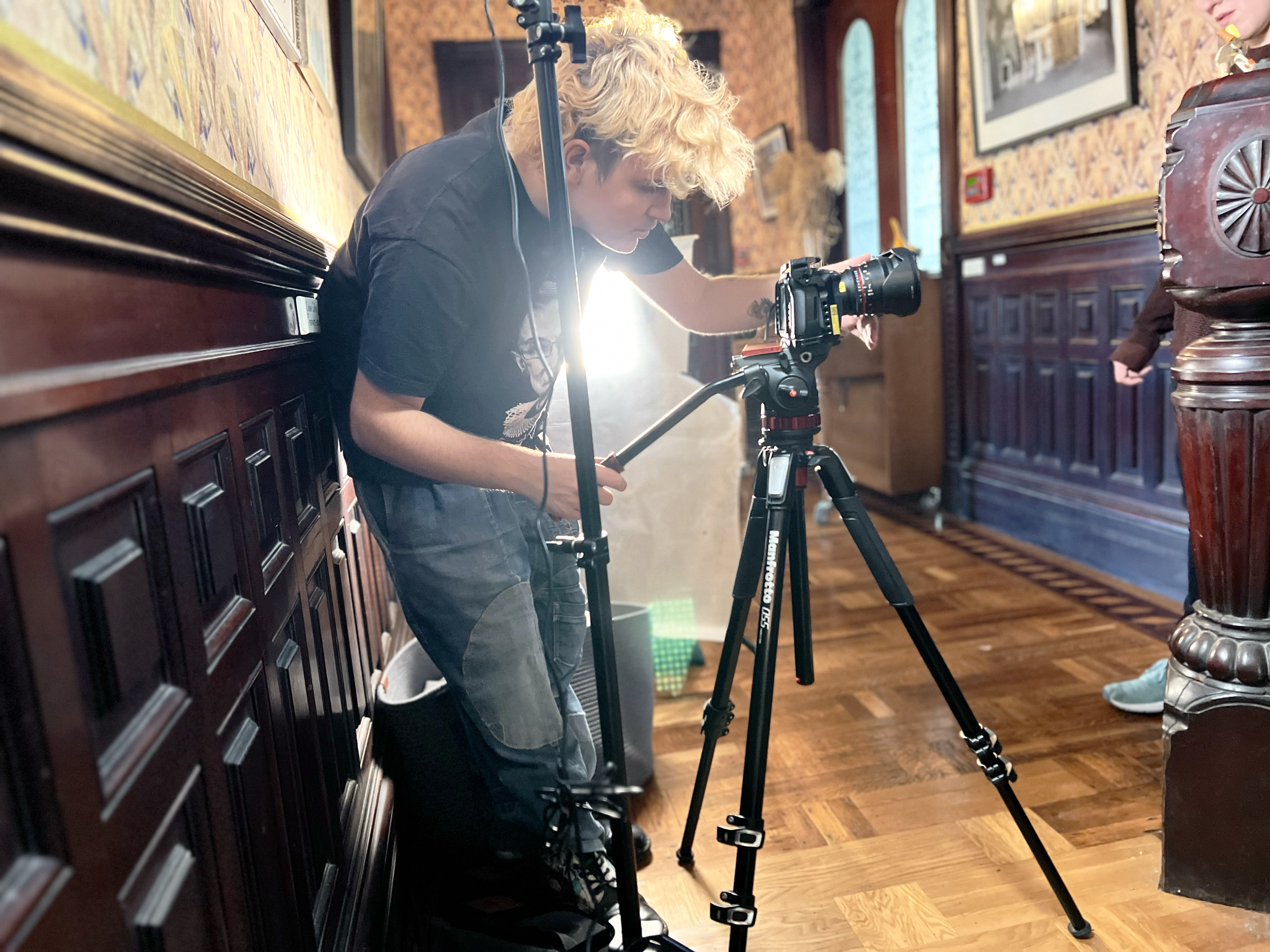 A student peers through the camera's lens during a shoot