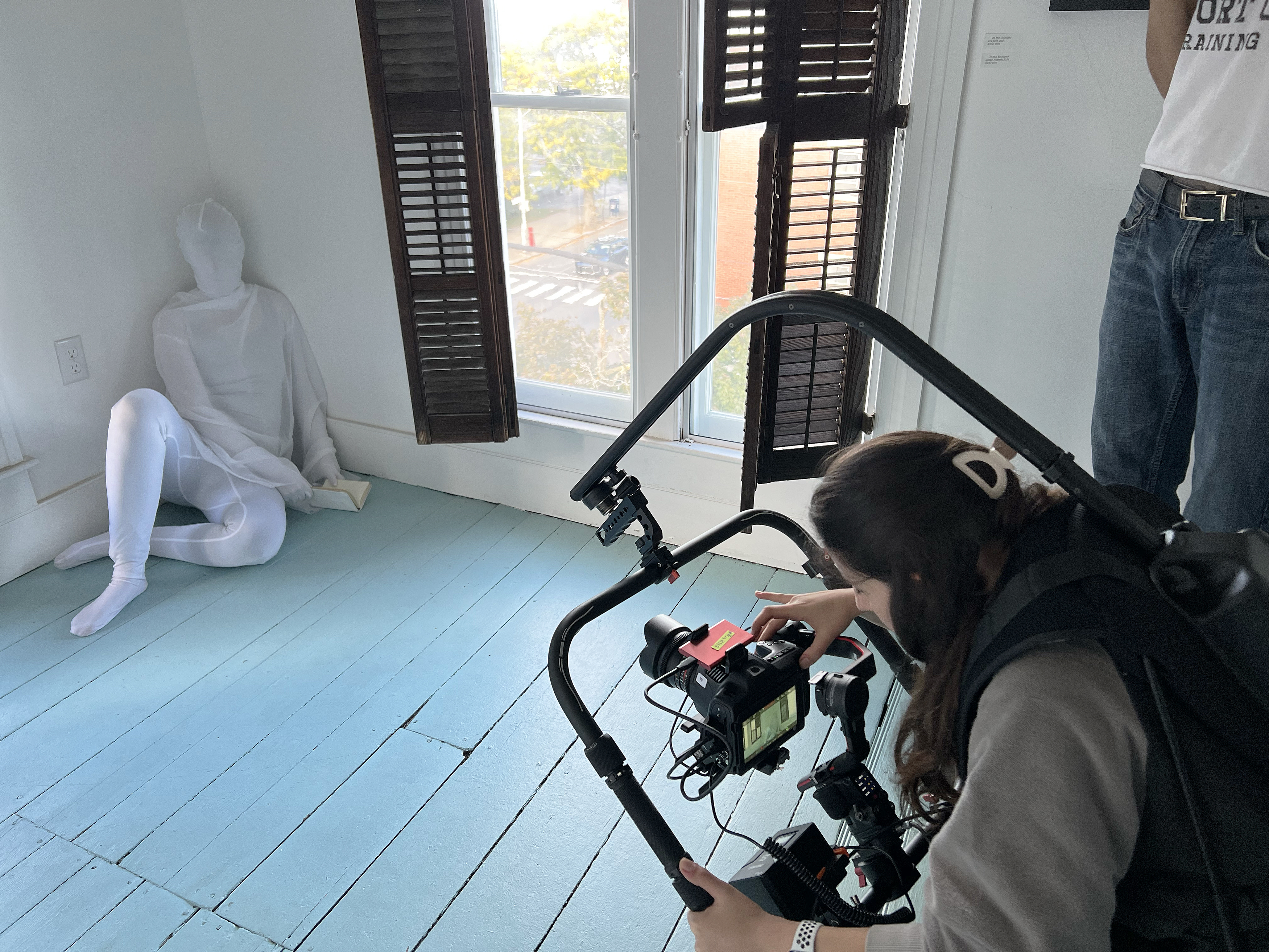 an actor dressed as a ghost is filmed in the corner of the attic