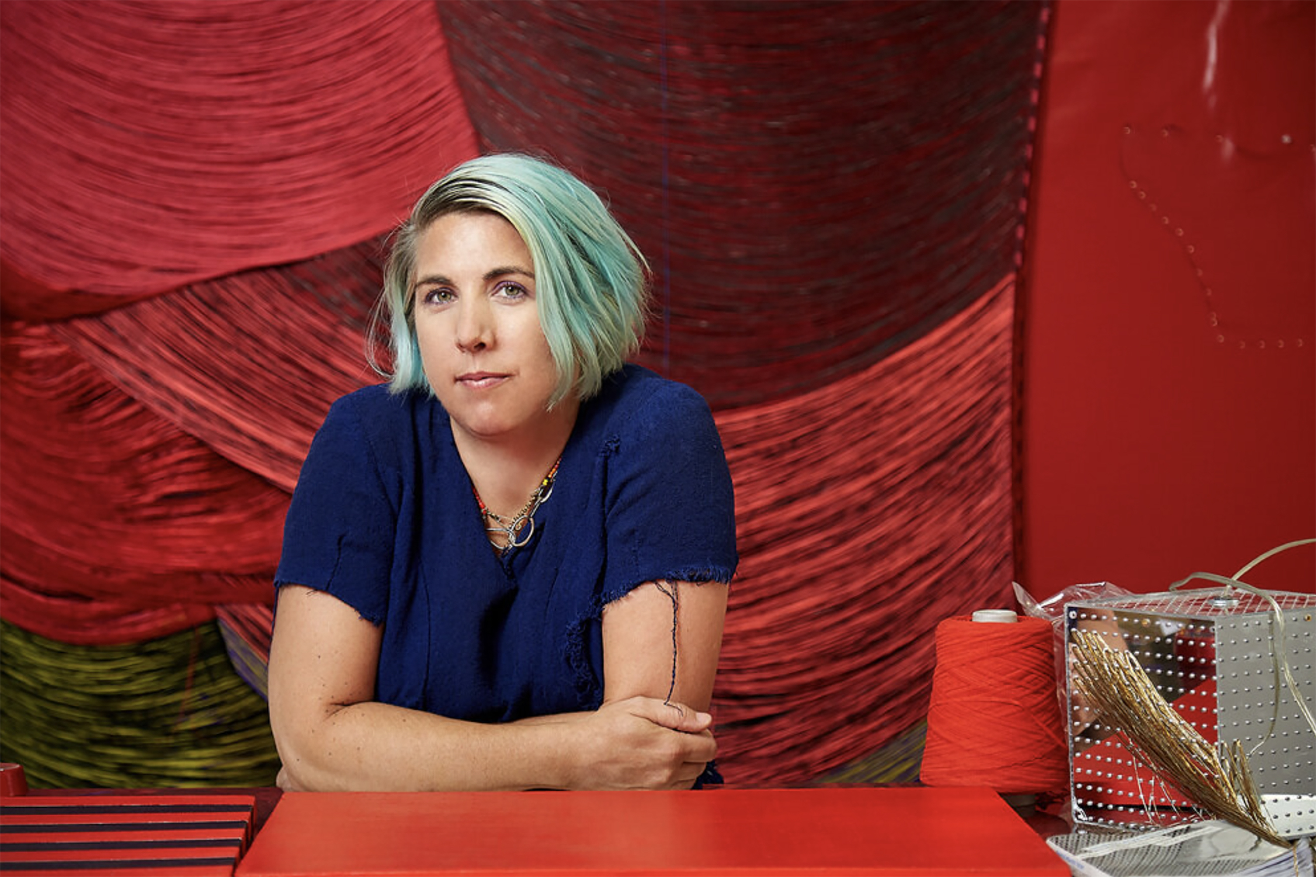 portrait of Liz Collins with red tapestry behind