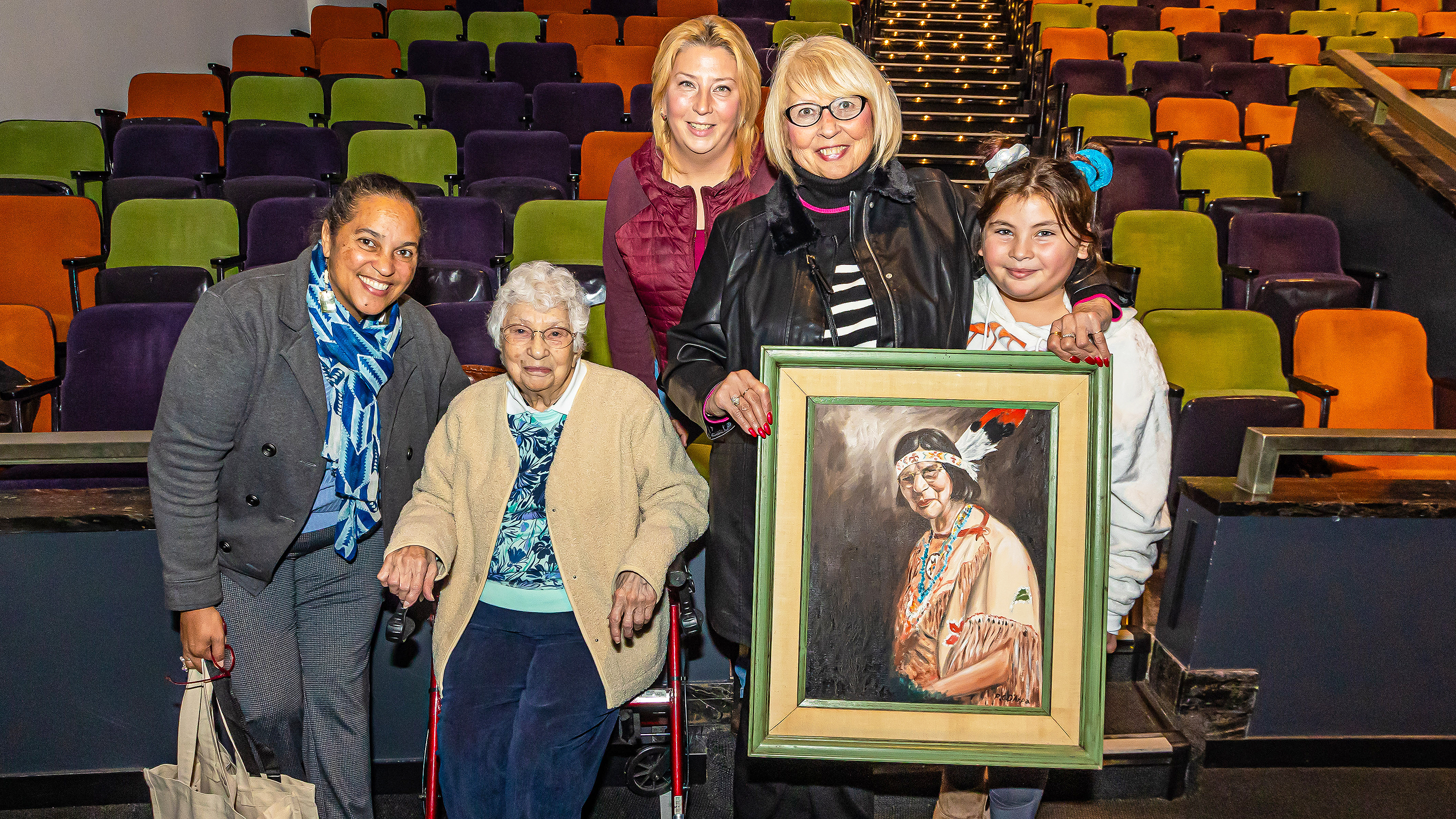Loren Spears and descendents of Princess Red Wing pose with her portrait in the RISD Auditorium
