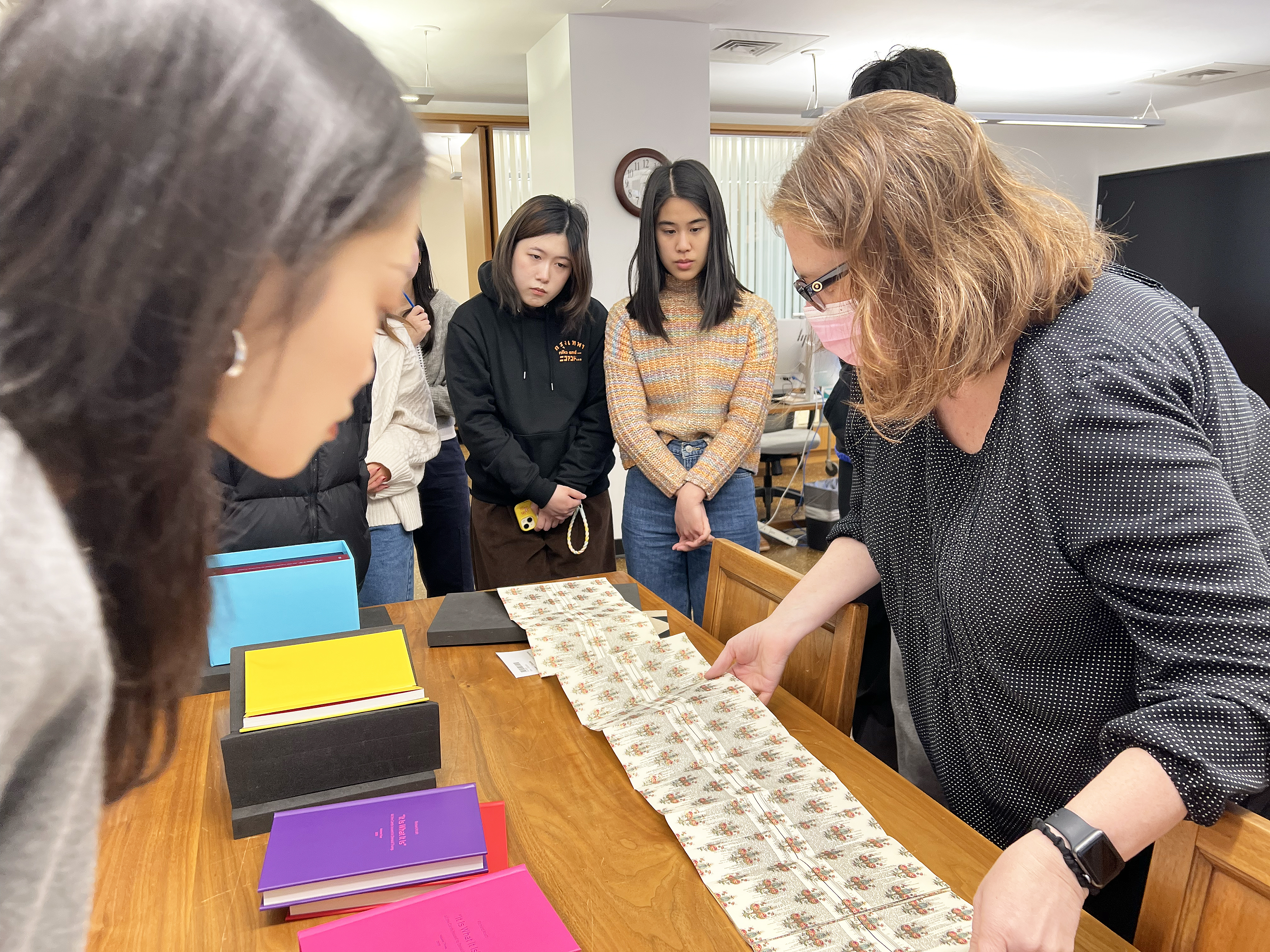 Special Collections Librarian Claudia Covert shows the class a piece from the 1970s