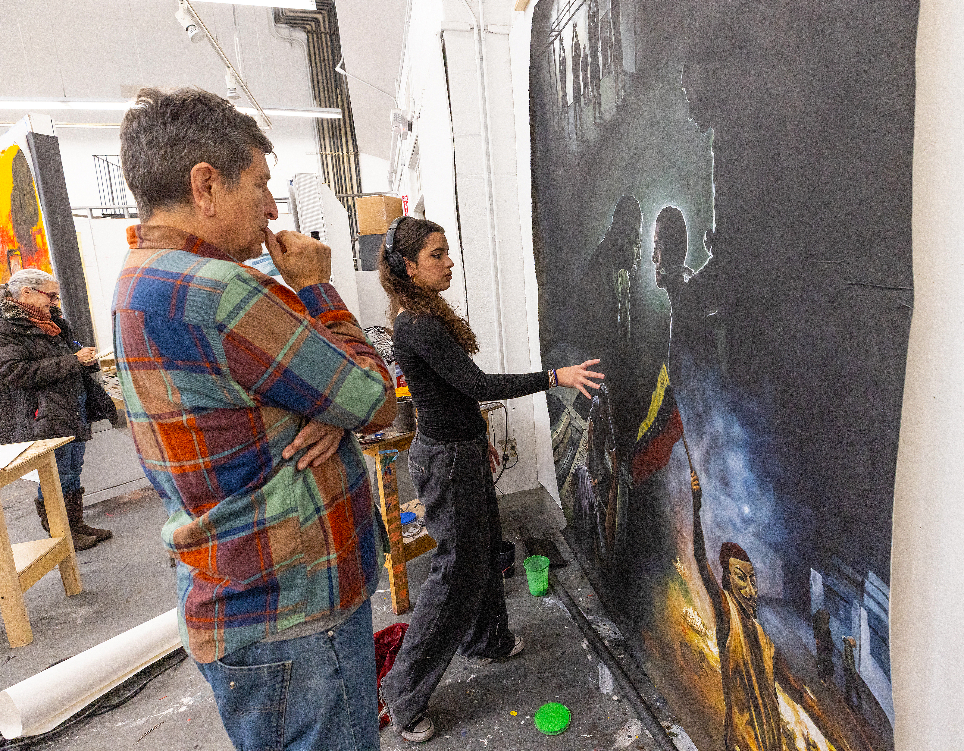 Ariana Chacon discusses a painting in progress with faculty member Mark Flores