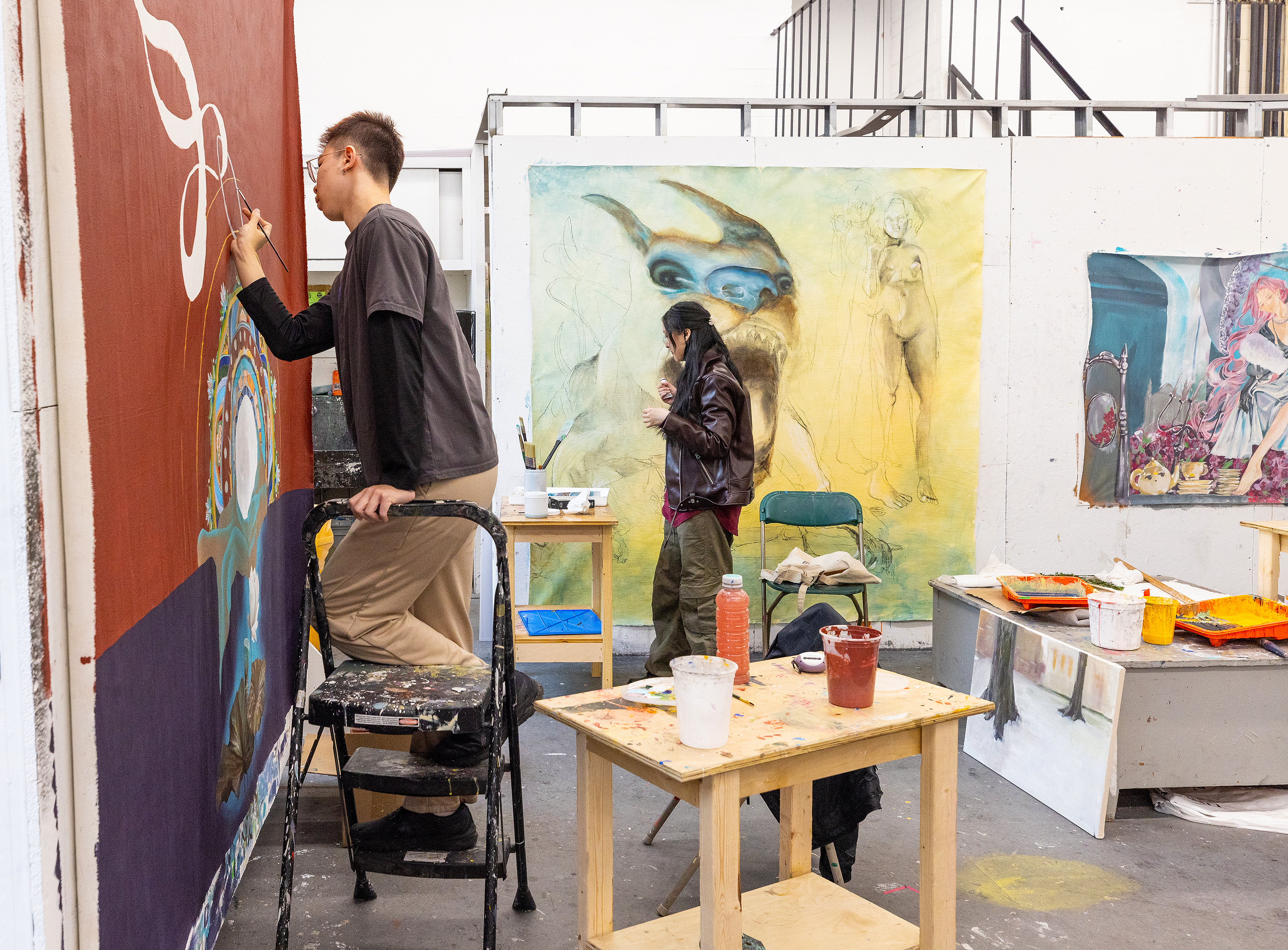 two students focusing on their large-scale paintings
