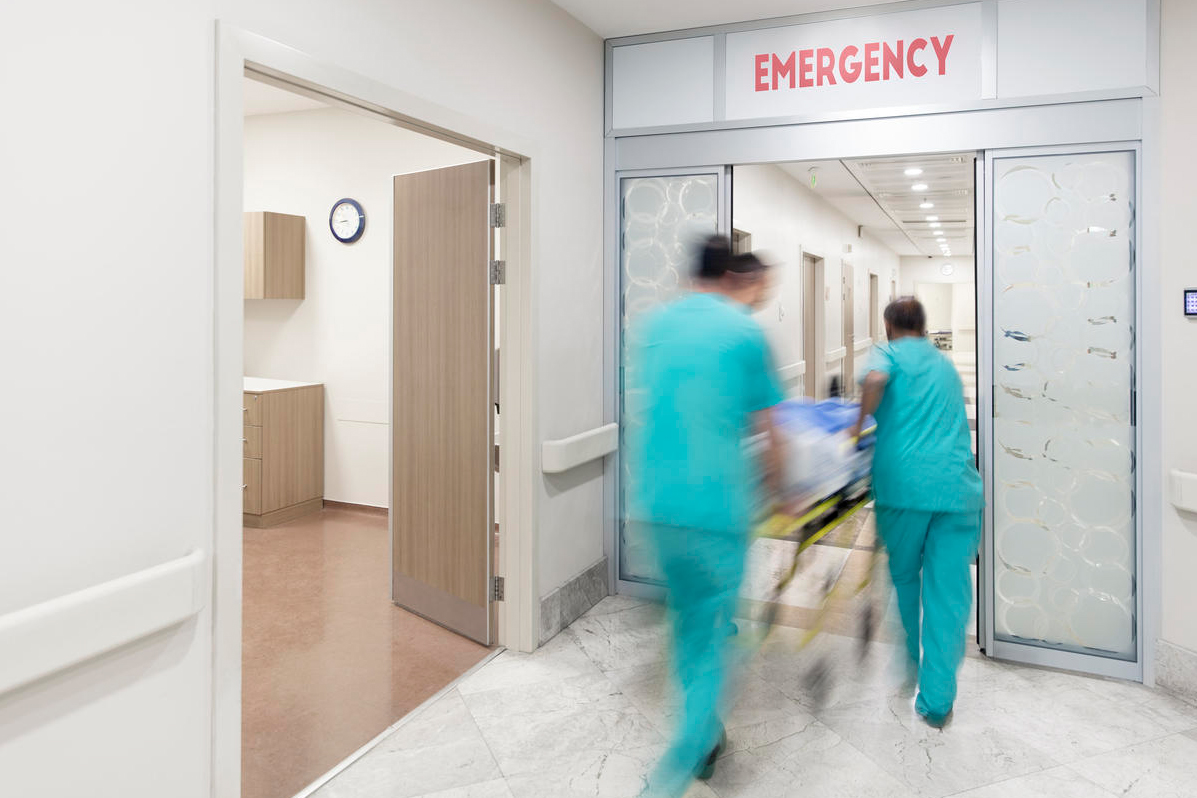 blurred photo of doctors wheeling patient into emergency room