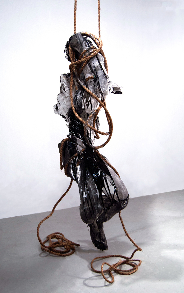 a frightening metal sculpture hanging from a rope