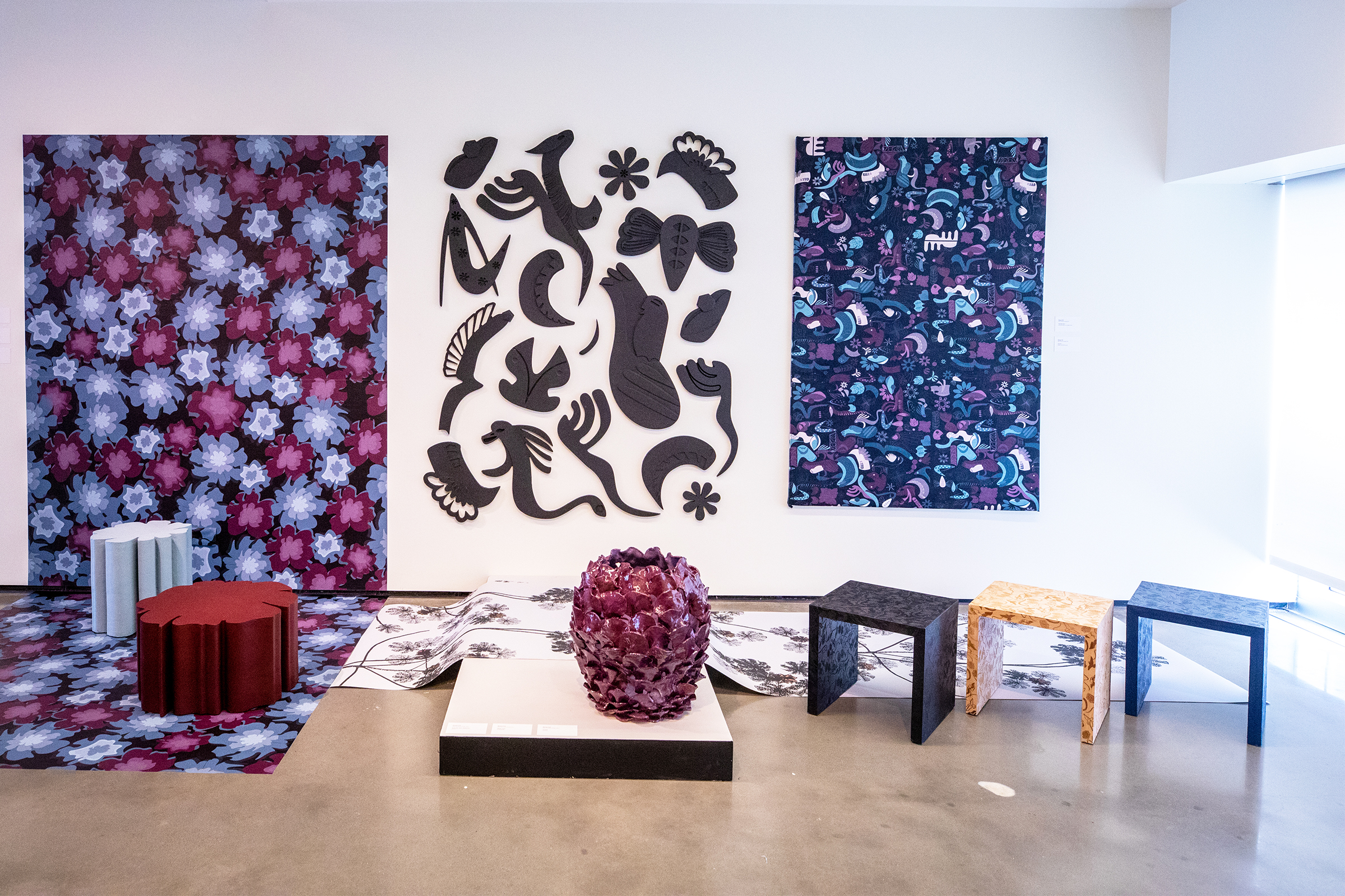 a series of colorful patterned wall hangings on display