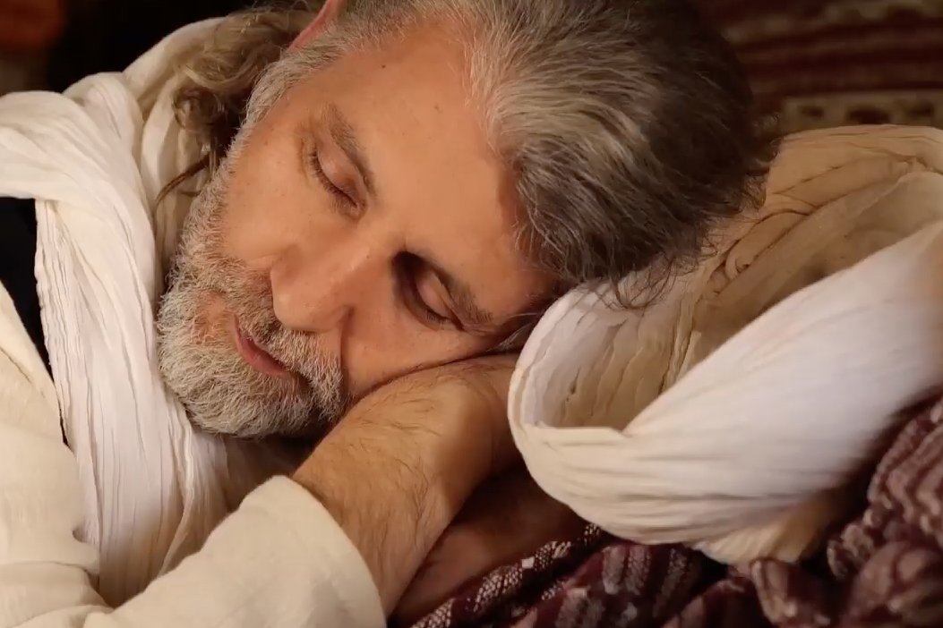 an older Turkish man rests his head