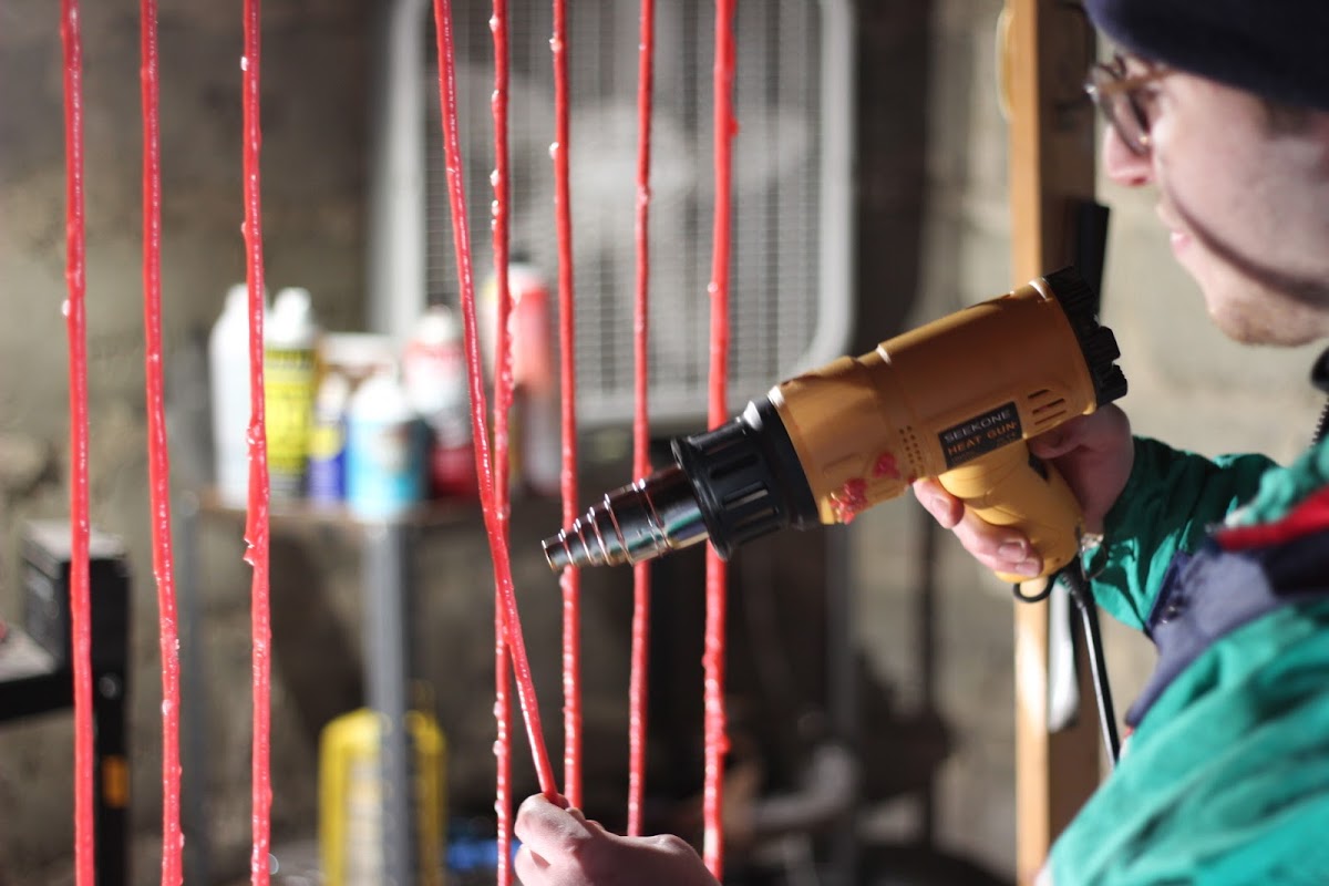 Student working on a piece using a heat gun