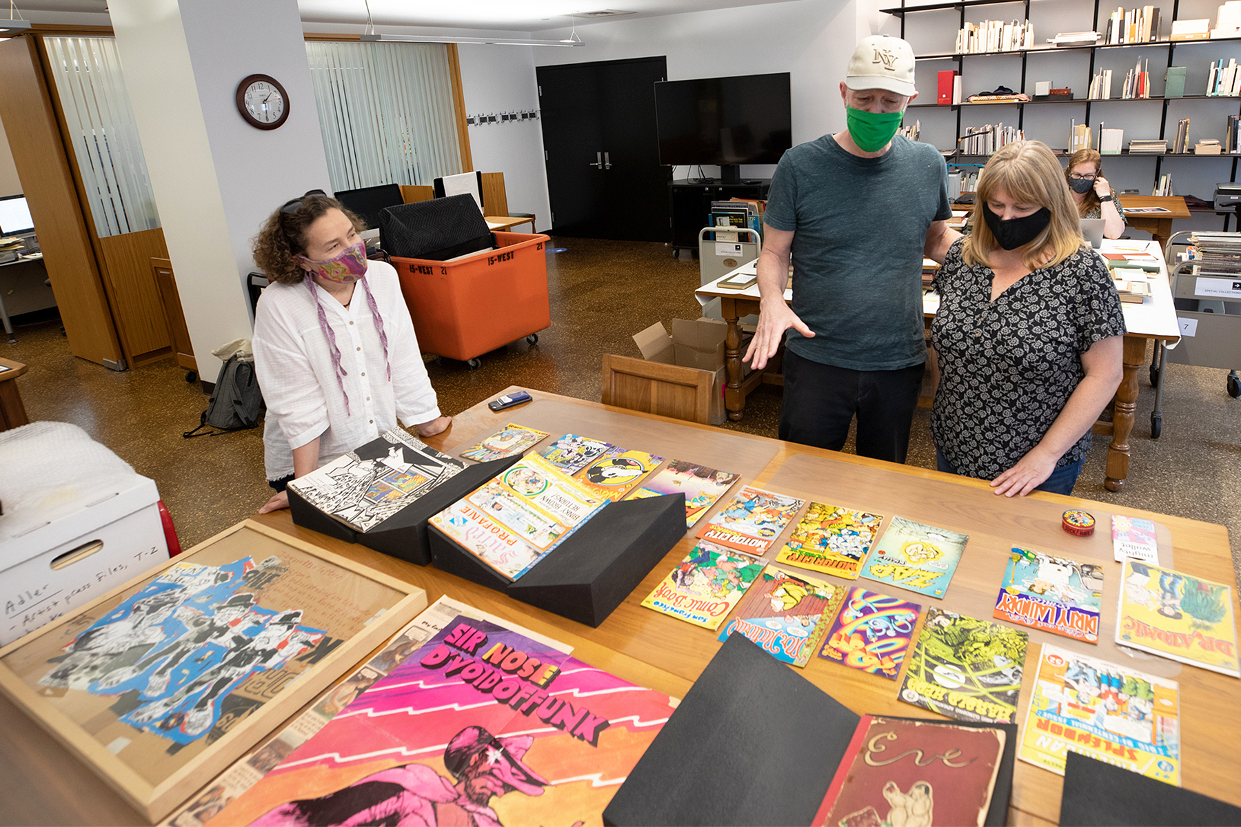 Adler and RISD librarians peruse a table full of underground comix