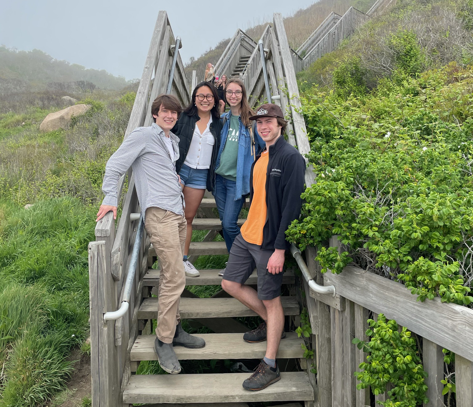 competition-winning student team poses on steps to beach