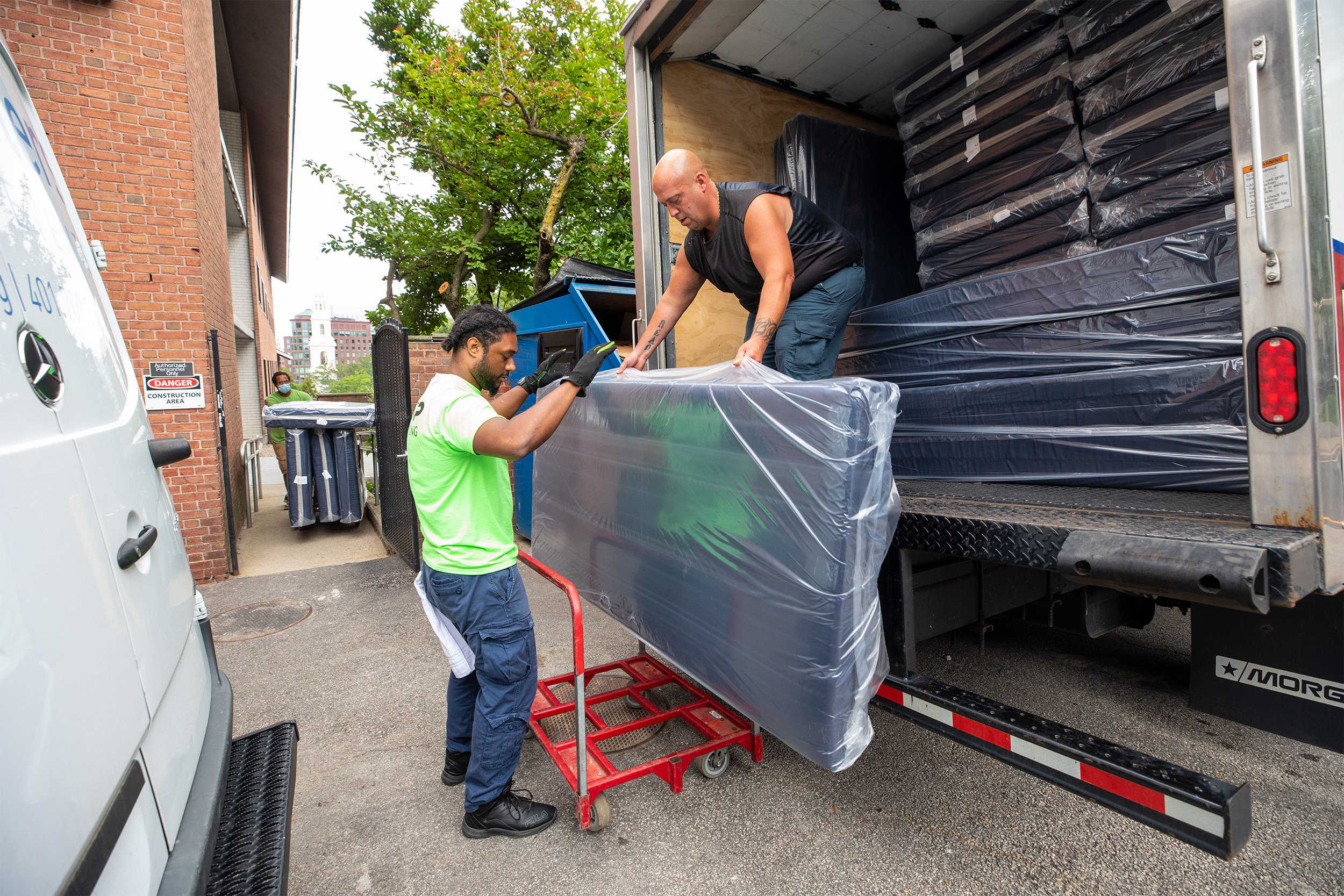 members of the facilities team unload tables from a truck