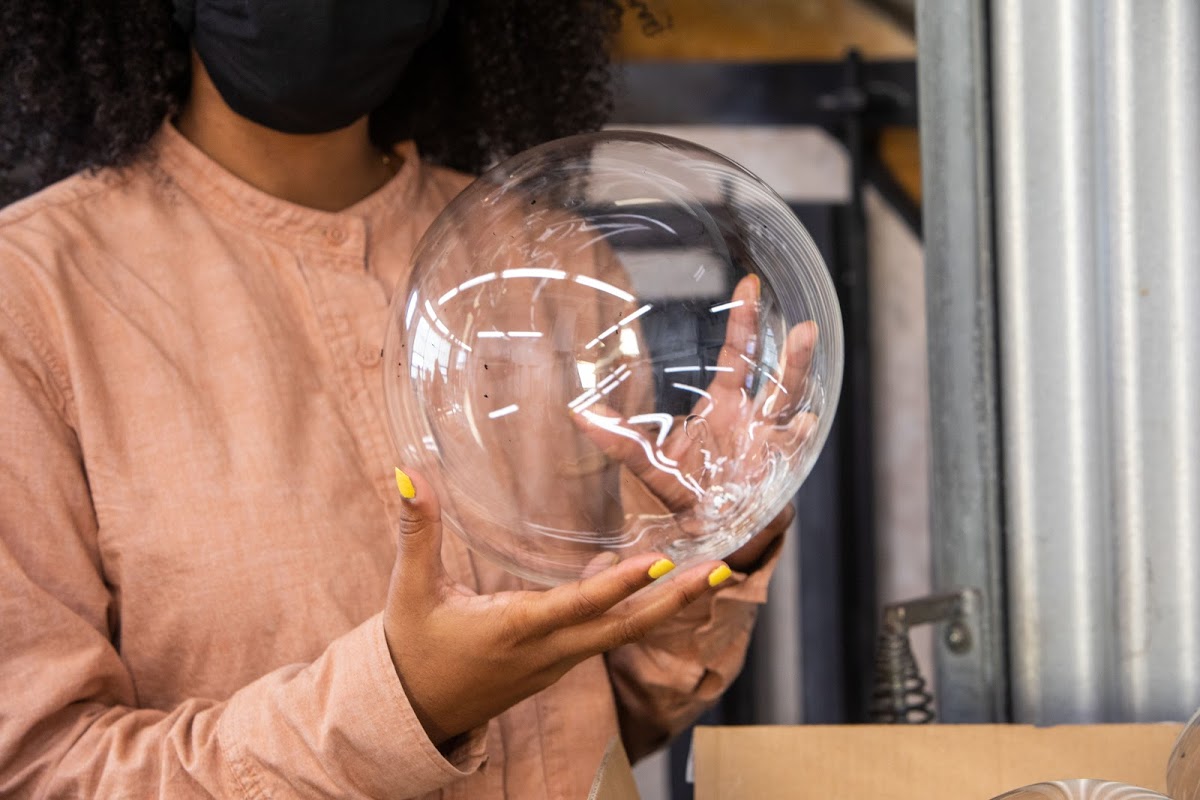 Masked student holds glass orb