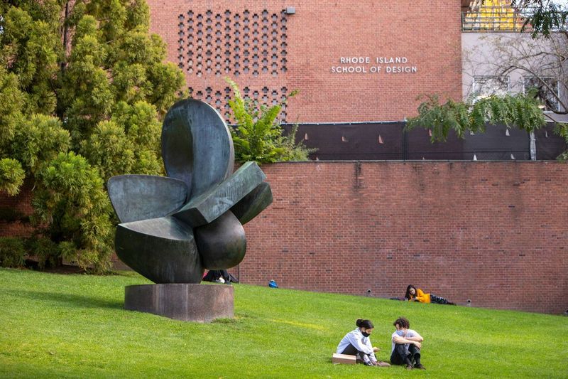 Masked students sitting/laying on RISD beach