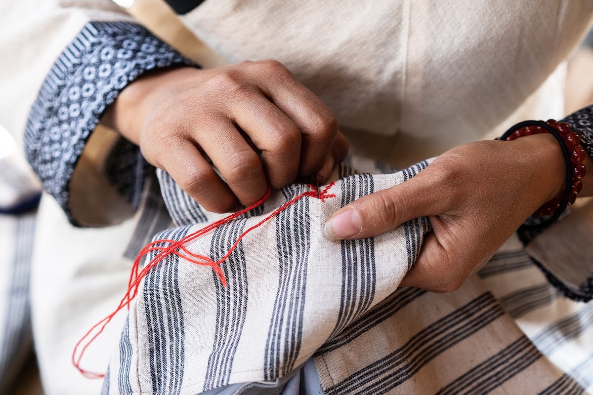 Hands embroidering fabric