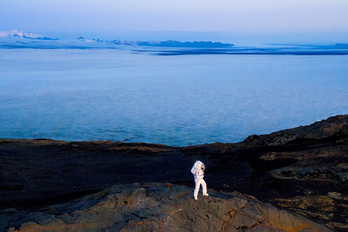Someone in spacesuit on other-worldly terrain