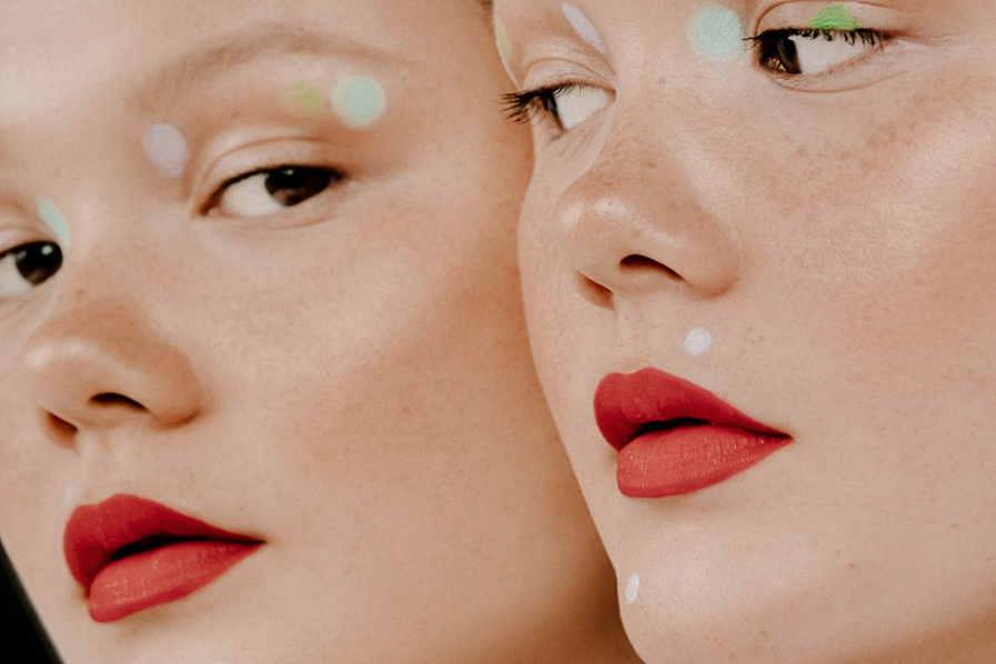 close-up of two identical models wearing unusual makeup