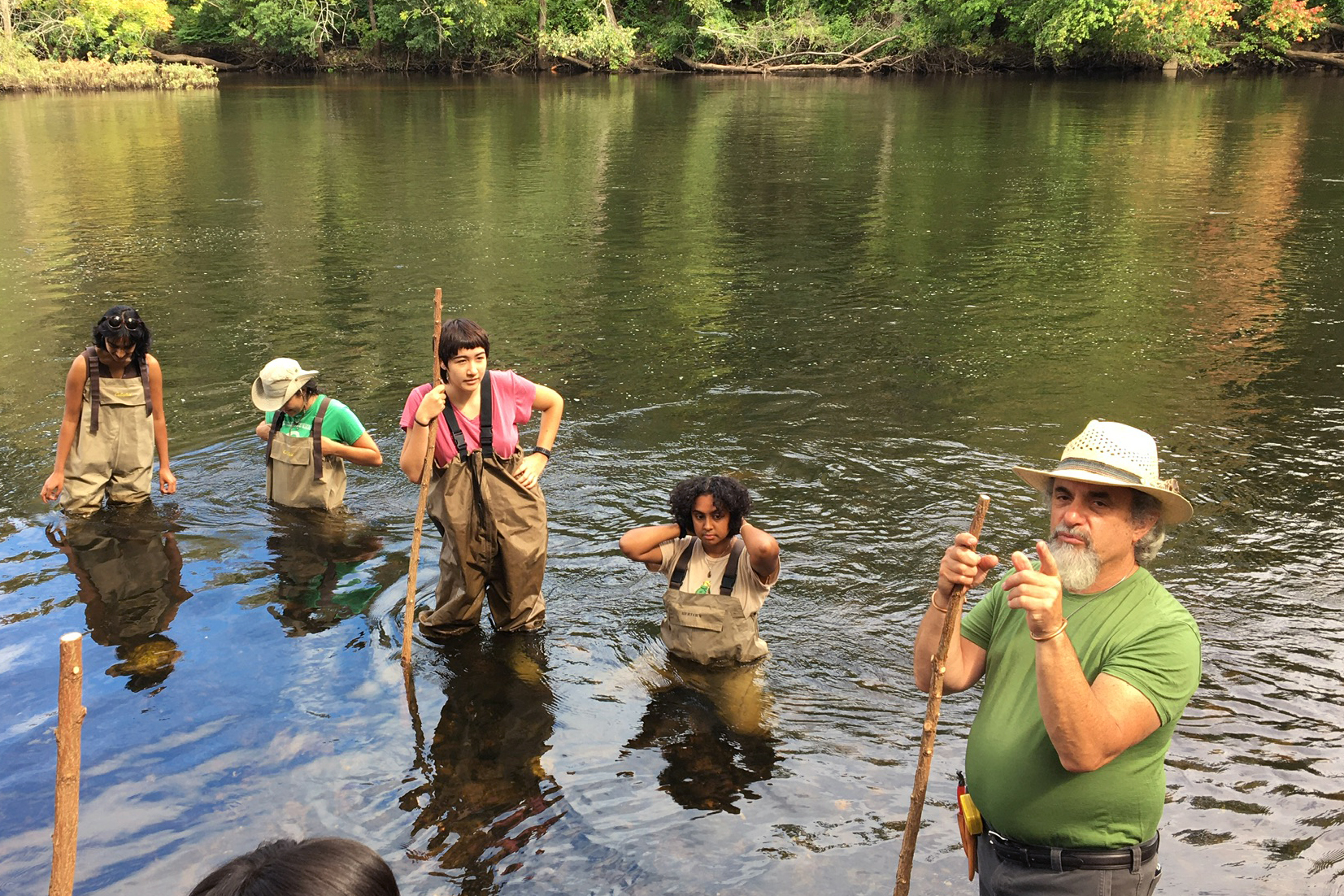 students in waders get right into the Blackstone River