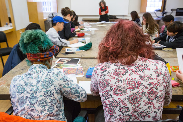 Two students with brightly-colored hair sitting next to each other in a classroom