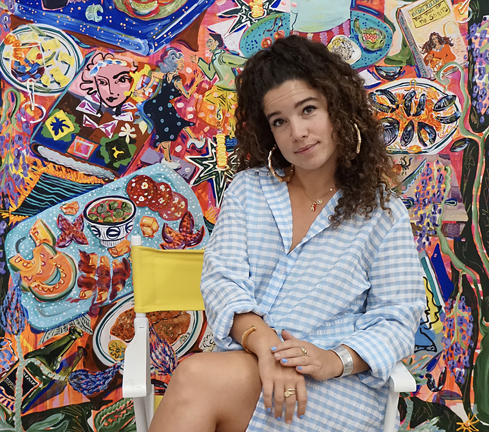 Pincus-Whitney poses in front of one of her colorful paintings