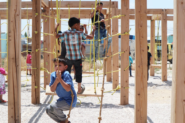Syrian children playing on a playground structure
