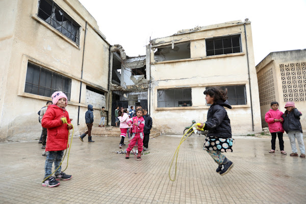 Syrian children playing outside a destroyed school in Hama, Syria.