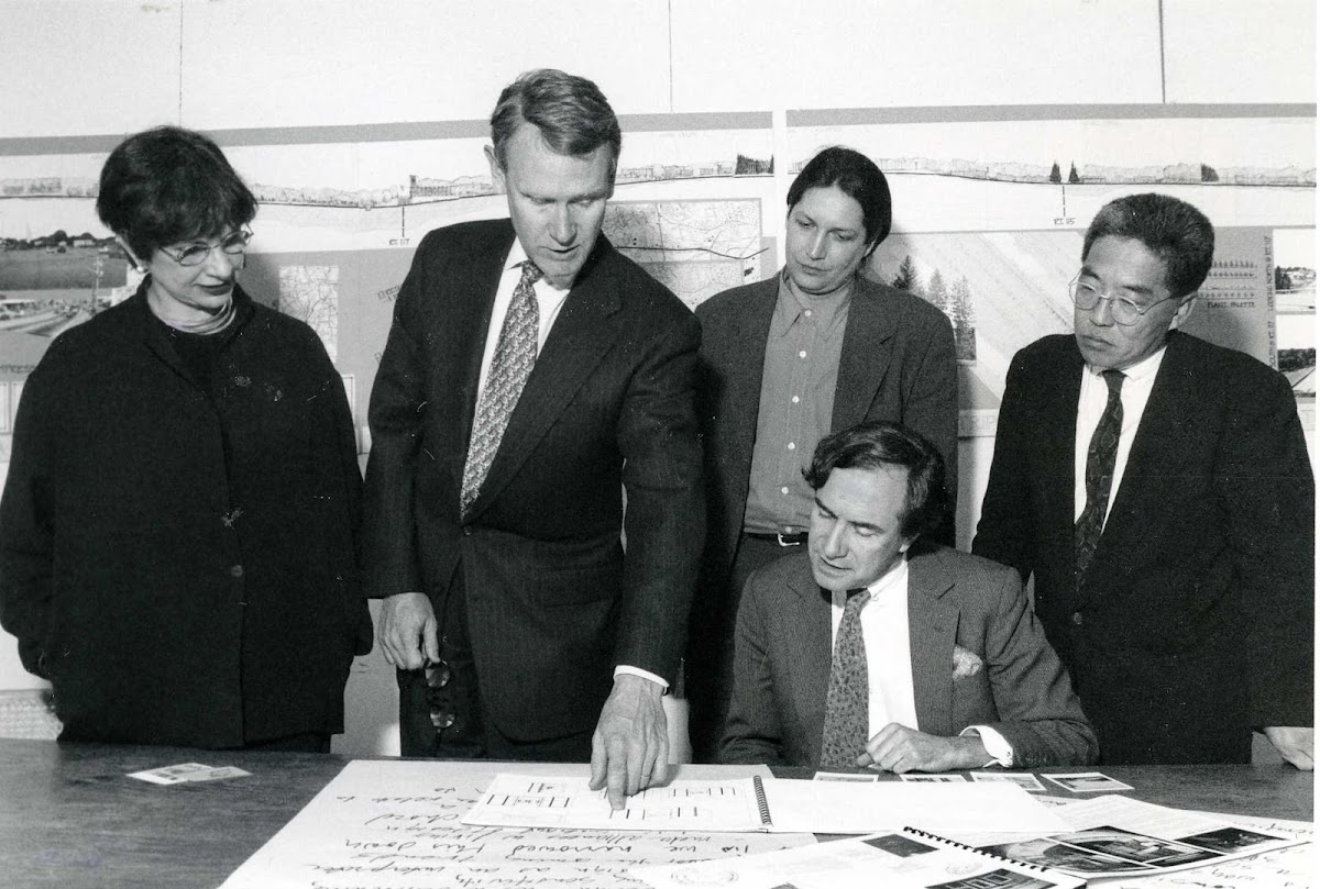 Roger Mandle reviewing something on paper with four individuals