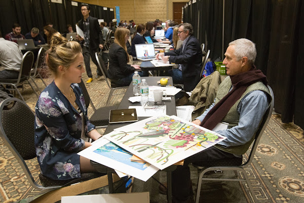 Student in conversation with a professional at the Design Portfolio Review