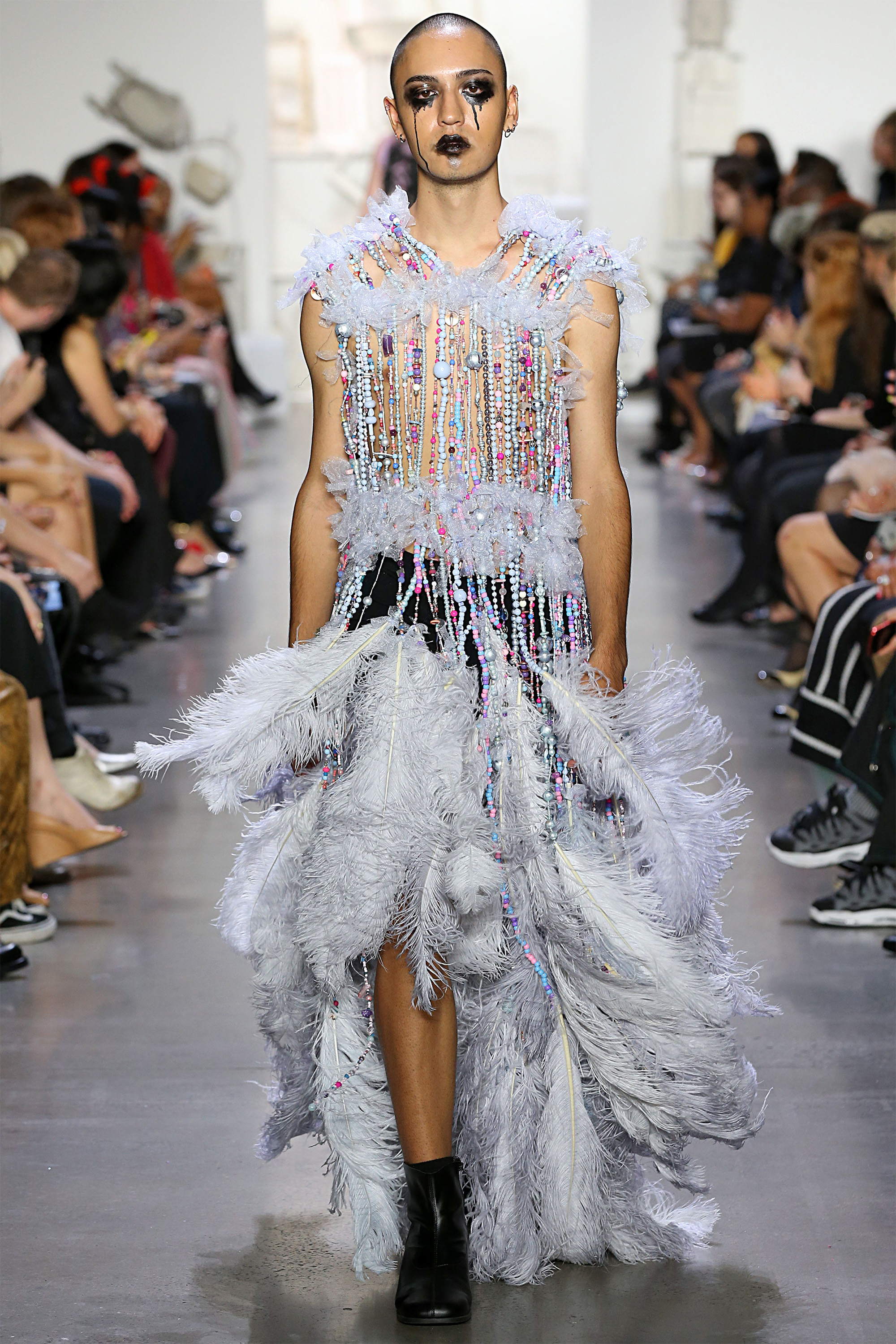 Model on runway wearing a beaded and feathered piece by Persephone Bennett 18 AP