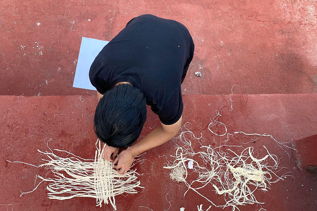 Person weaving straw